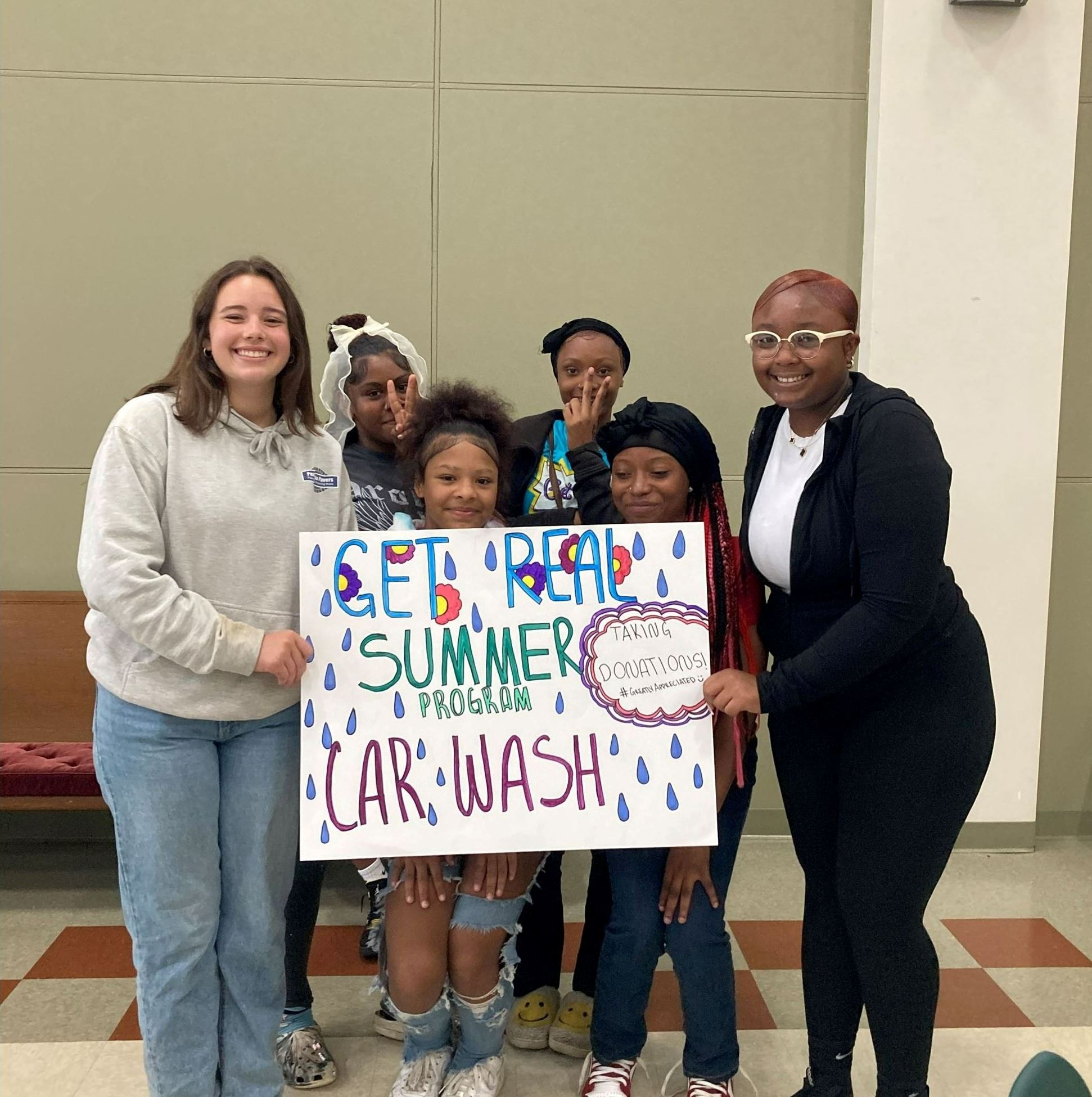Photo of kids holding Get Real Car Wash Sign