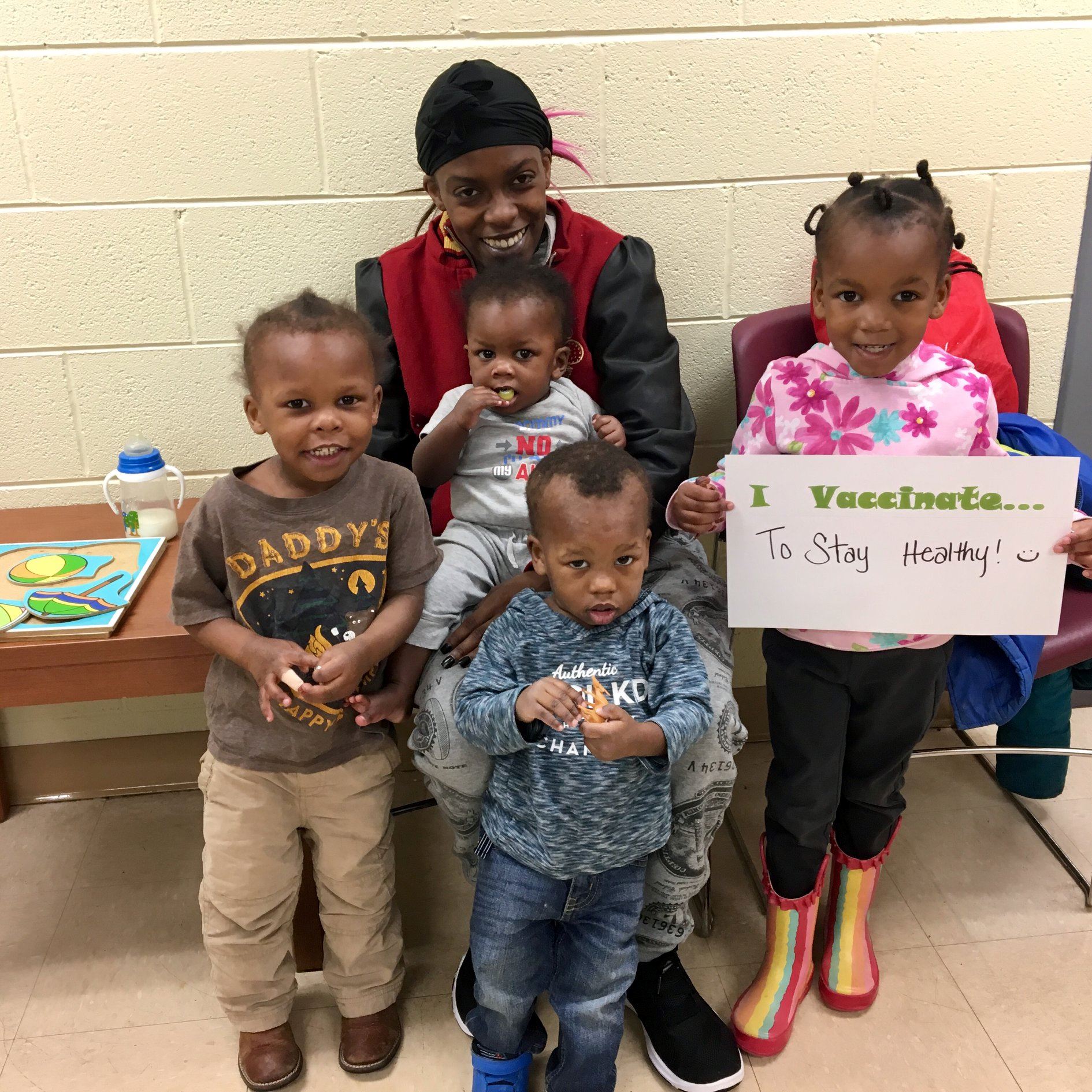 A family holding a sign that says, "I vaccinate to stay healthy."
