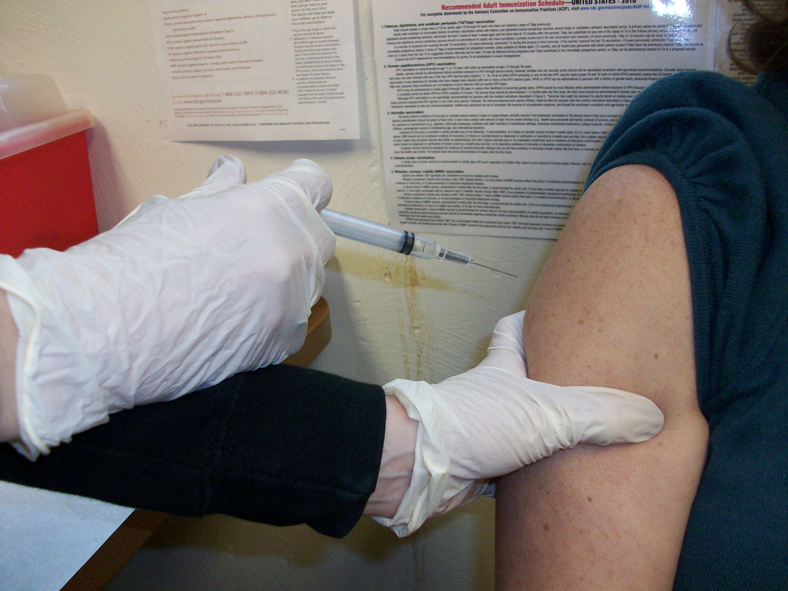Photo of a nurse delivering a vaccine into someone's arm.